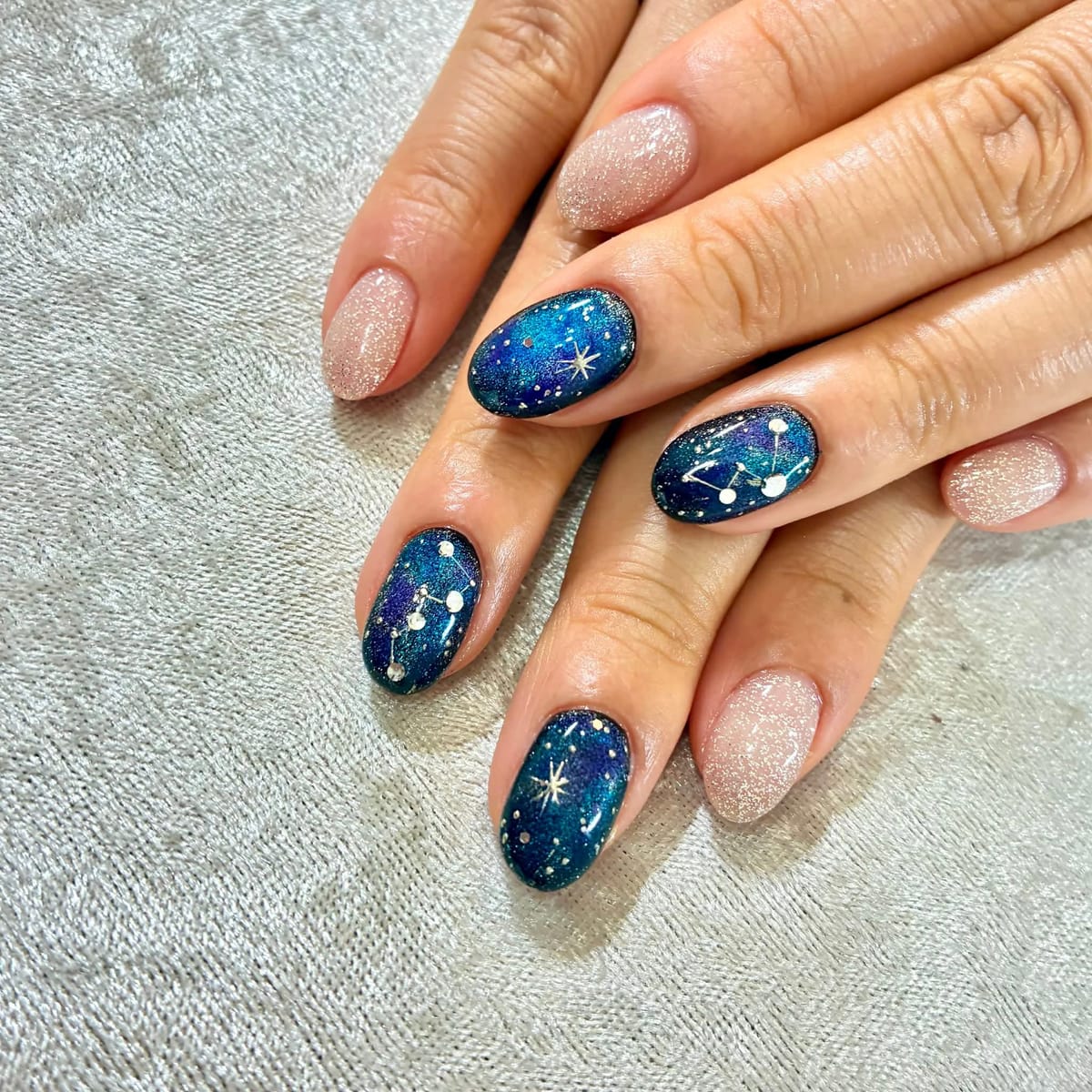 夜空のような深いブルーに星や星座を描いた星空ネイル